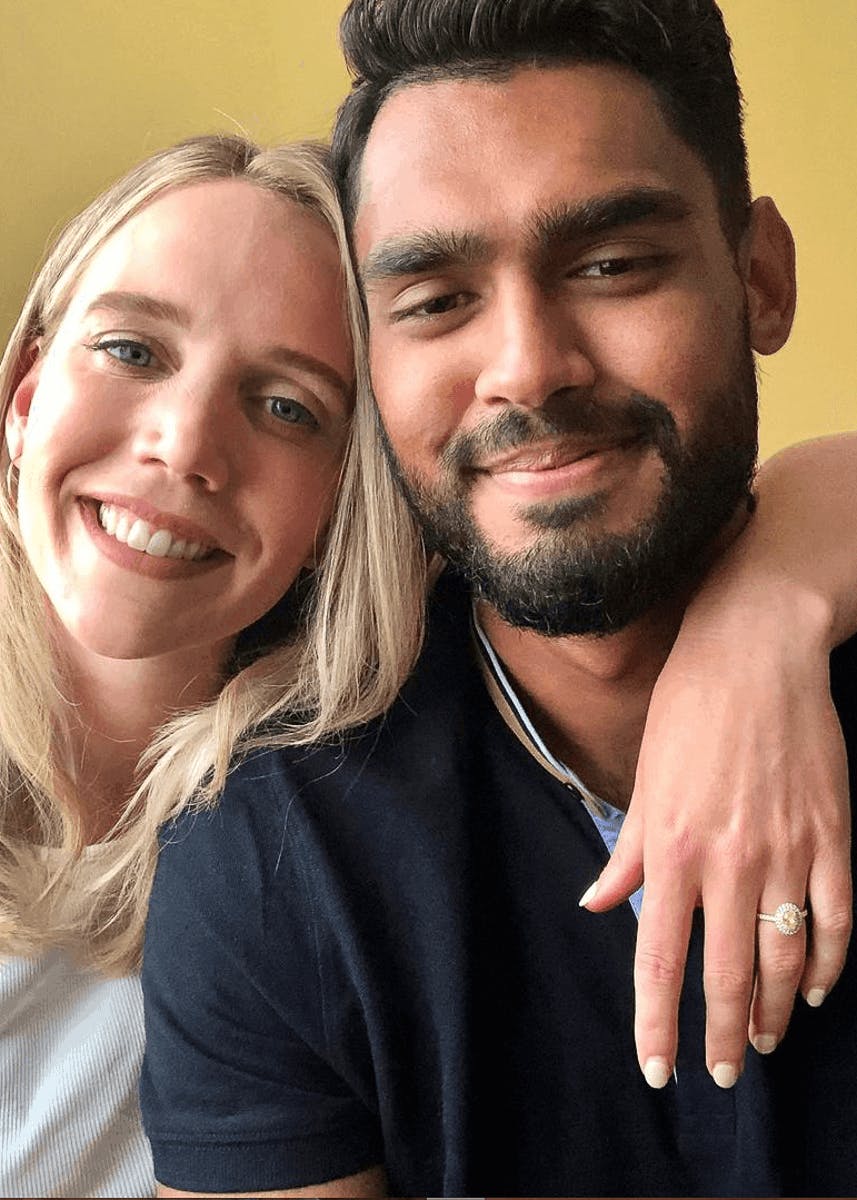 Happy couple just engaged, showing off their bespoke diamond engagement ring and smiling