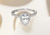Pear shape platinum halo engagement ring, with the tip of the pear diamond resting on a tile