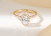 Yellow gold halo engagement ring with a pear shape diamond, white a diamond set halo and band