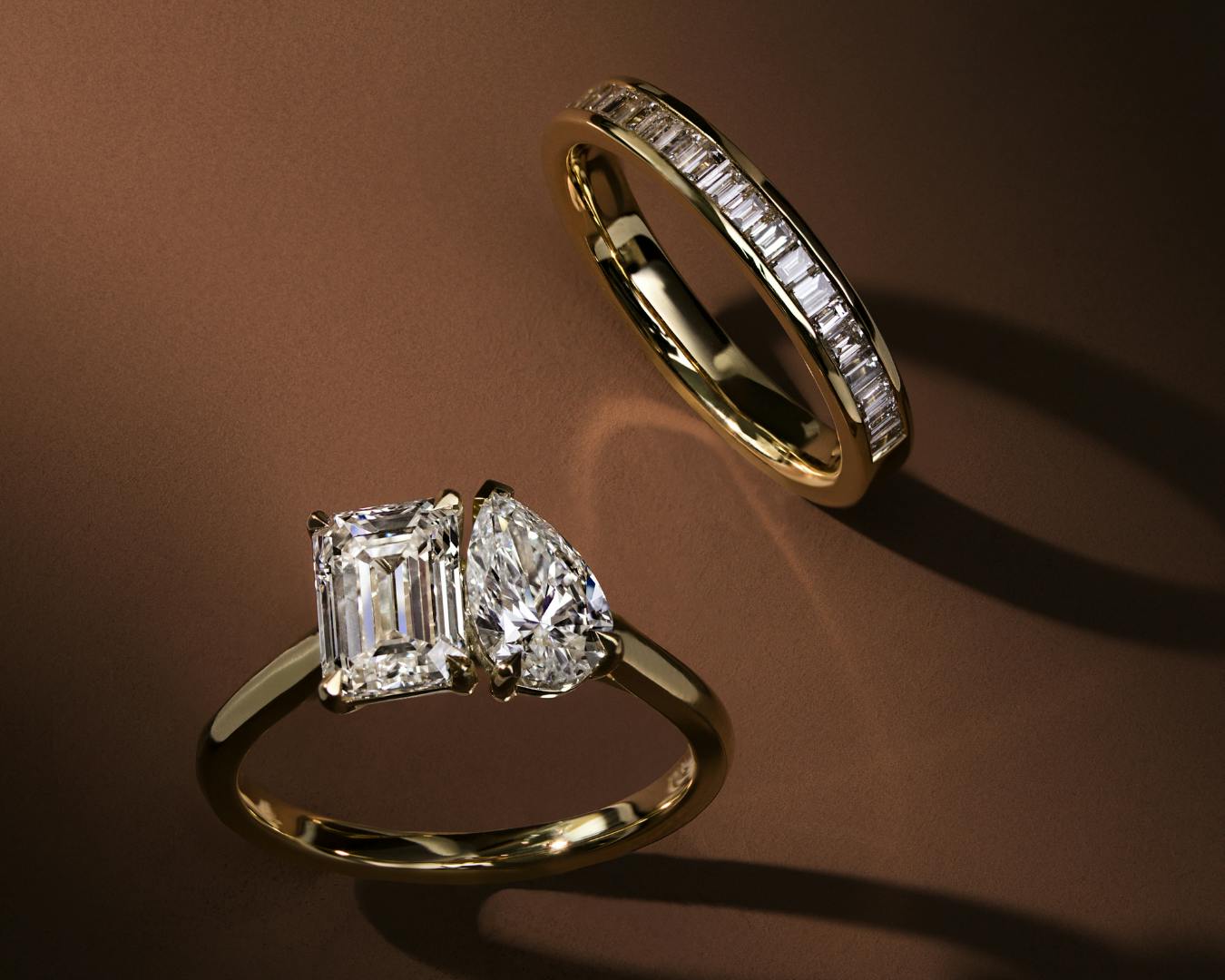 Toi et moi engagement ring with emerald and pear cut diamonds, and bespoke diamond wedding ring in yellow gold.