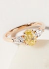 three stone engagement ring with one oval yellow diamond and two pear diamond sides