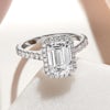 Big 2ct emerald cut lab grown diamond ring with a halo of small diamonds and small diamonds along the band