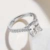 A square princess cut lab diamond ring with small diamonds along the band on a white background