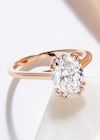 Unique, custom rose gold solitaire ring with a large 2ct oval diamond and bespoke, triple claws