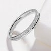 A simple platinum wedding ring with small channel set diamonds on a white background