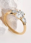 Oval shape trilogy engagement ring with two side diamonds in pear shape