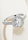 Round diamond halo platinum engagement ring with a diamond set shank, set in scallop style