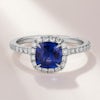 Cushion shape sapphire halo engagement ring with diamond halo and diamond band by Queensmith