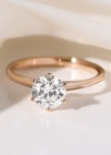 Round solitaire diamond engagement ring with plain band in rose gold