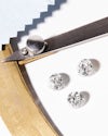 Three loose diamonds along with diamond measuring tool and polishing cloth