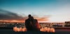 Couple looking out over a city skyline surrounded by candles.