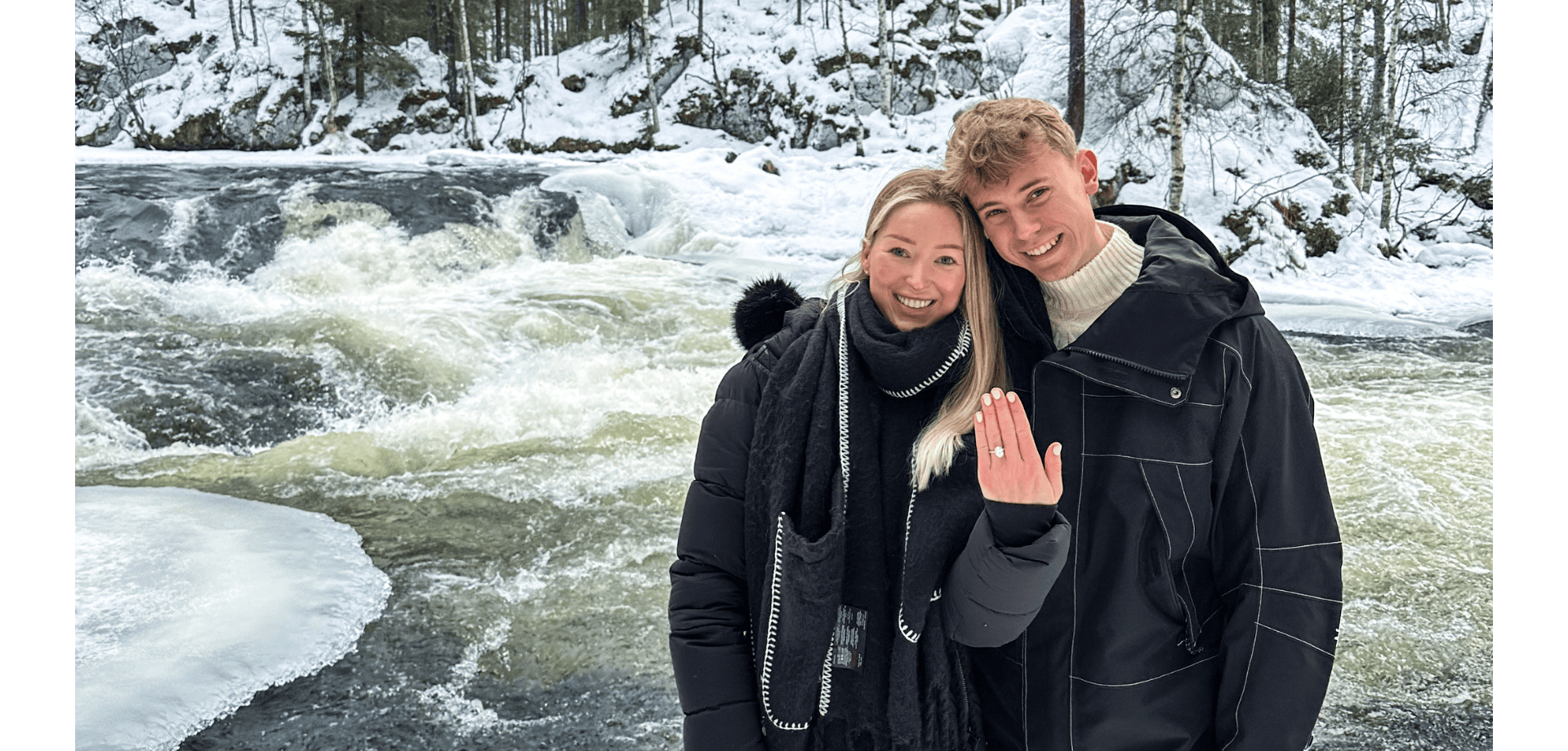 Queensmith couple pose with oval diamond engagement ring against snowy backdrop.