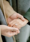 Man holding woman's hand to show her engagement ring. They are a newly engaged couple