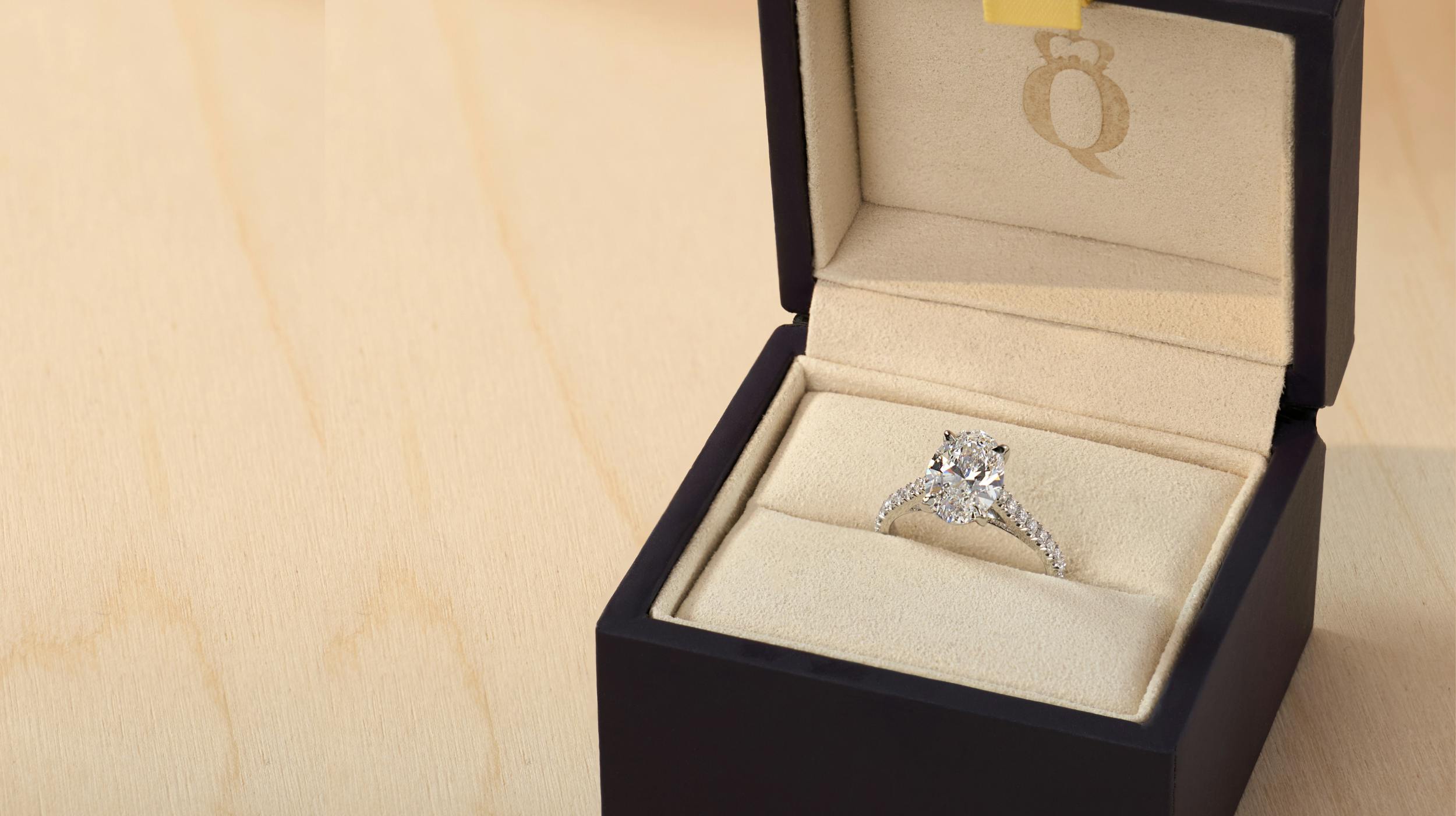 Bespoke round diamond band platinum ring in Queensmith ring box.