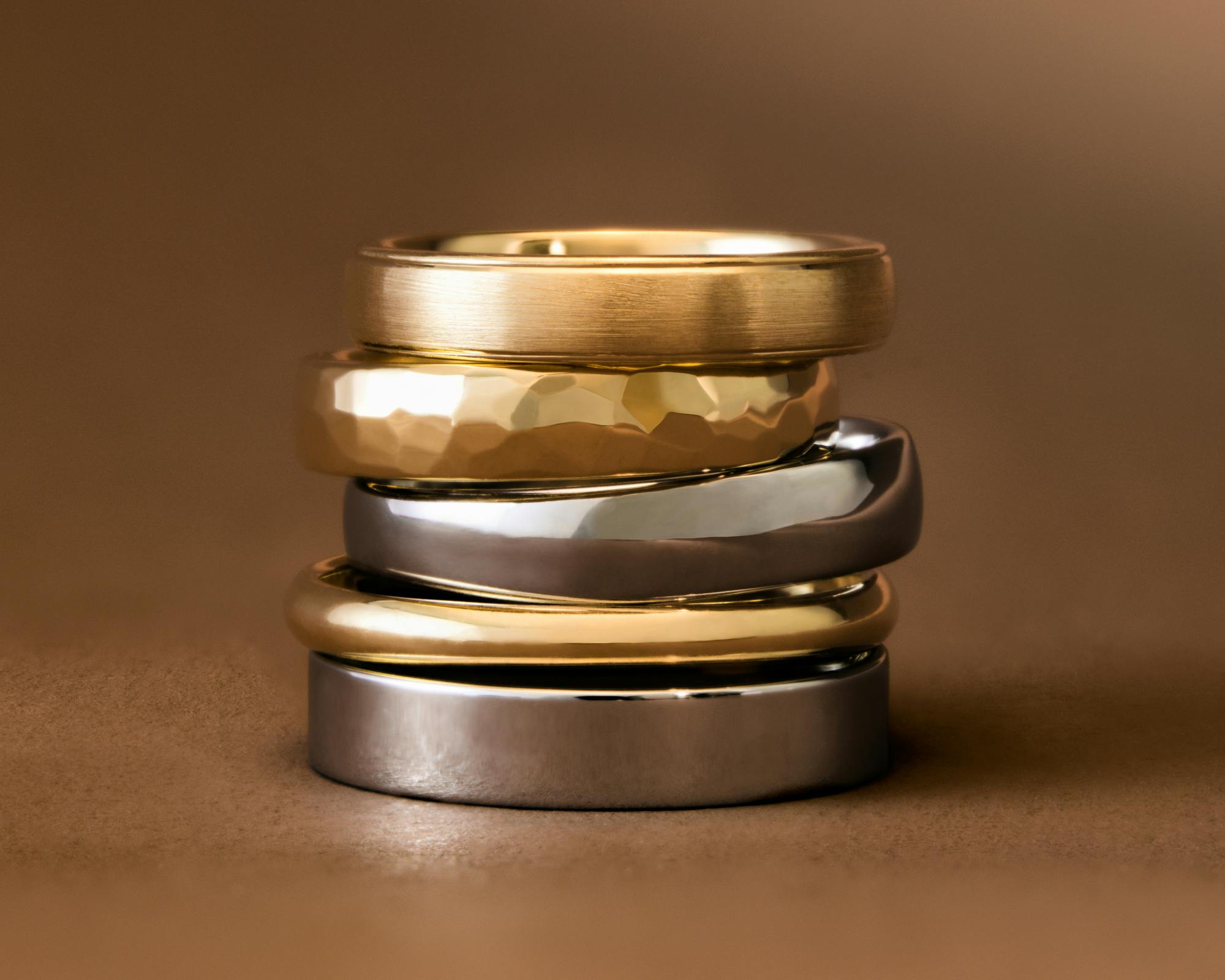 chunky wedding rings in different metal types stacked on top of one another