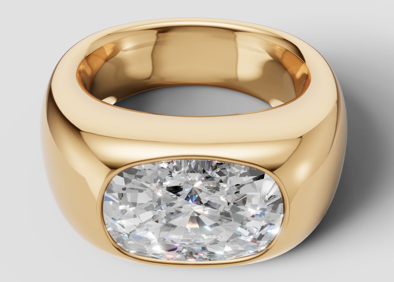 Downward angled Queensmith's render of Miley Cyrus's engagement ring with an elongated cushion cut diamond, set east-to-west on a chunky yellow gold bezel band.