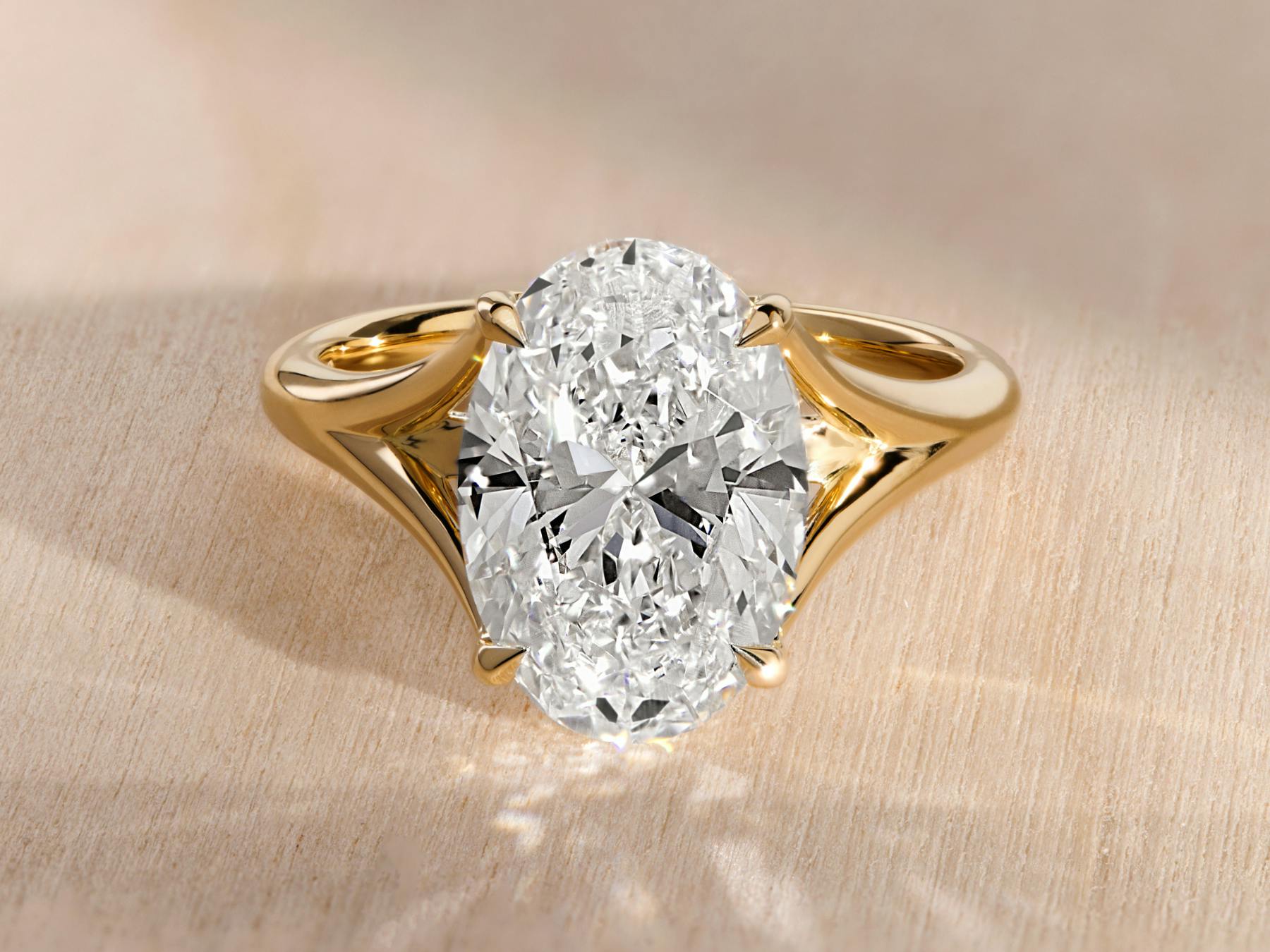 Solitaire engagement ring with oval diamond and yellow gold setting.