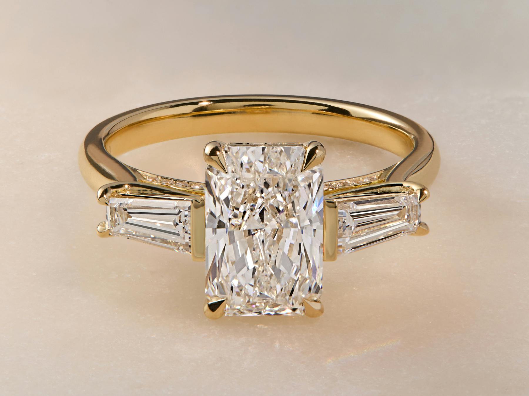 Trilogy engagement ring in yellow gold.