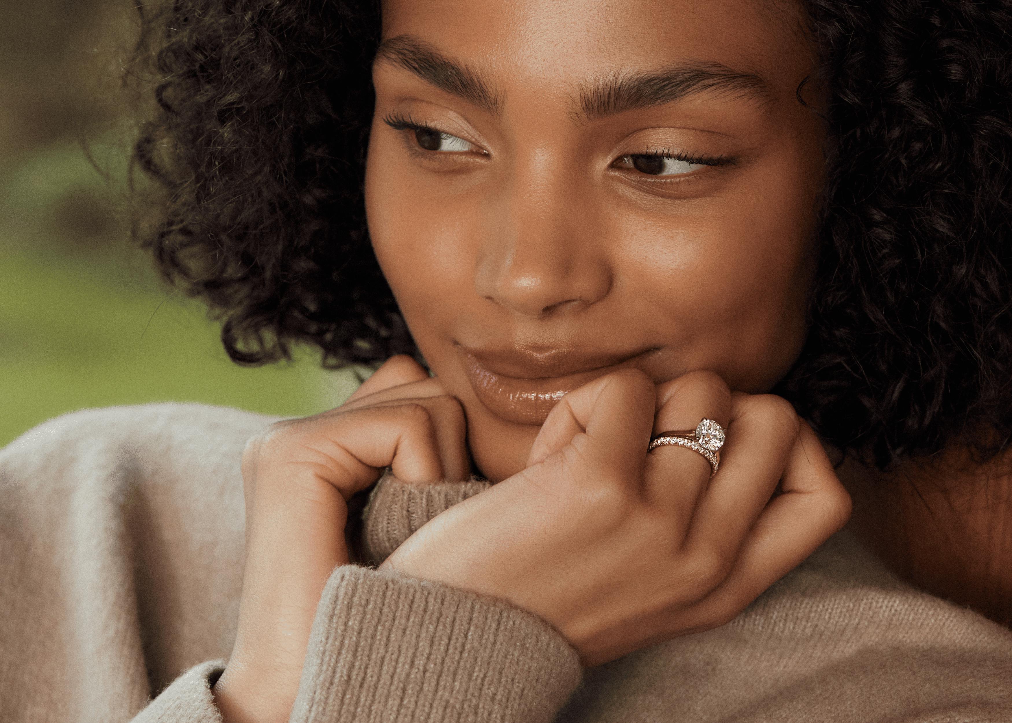 Woman wearing Round brilliant engagement ring stack with diamond wedding band.