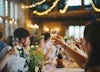 Wedding guests raise their glasses to toast the bride and groom.
