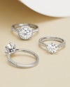 Three platinum engagement rings showing the difference between a halo ring, diamond band ring and solitaire ring