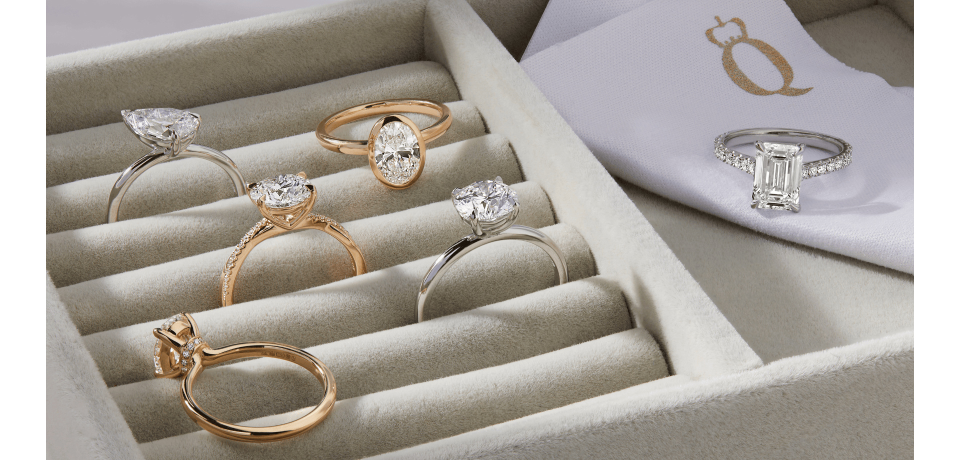 Tray of diamond engagement rings with different metal settings, including platinum, yellow gold and white gold.