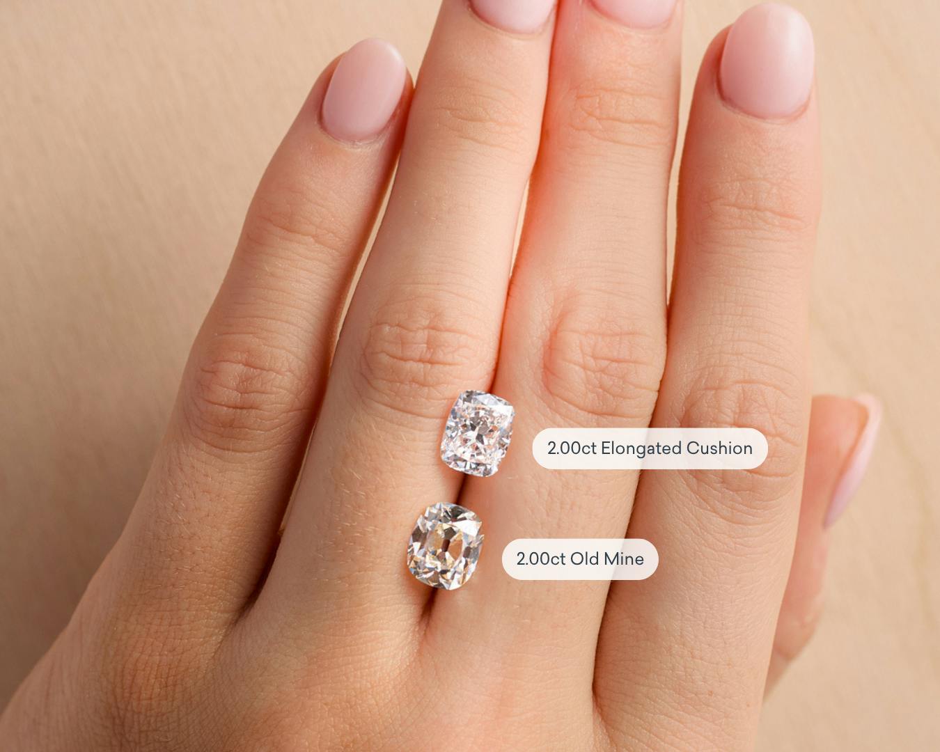 Elongated cushion cut diamond and old mine cut diamond resting on a hand.