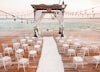 Outside wedding with ocean sunset backdrop.